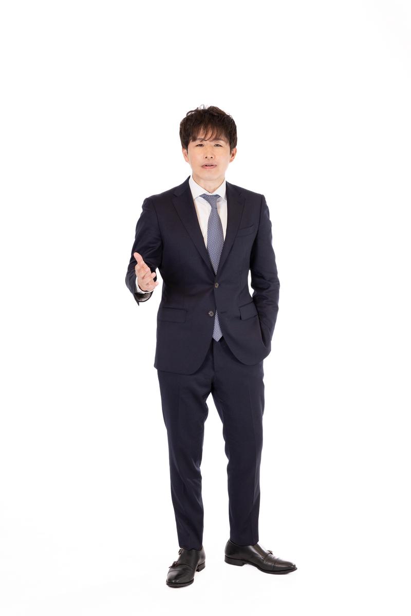 紺色のスーツを着たM&Aアドバイザーが握手を促す男性［モデル：野崎繁裕］