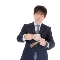契約金を現金で数えるM&Aアドバイザーの会社員男性の写真