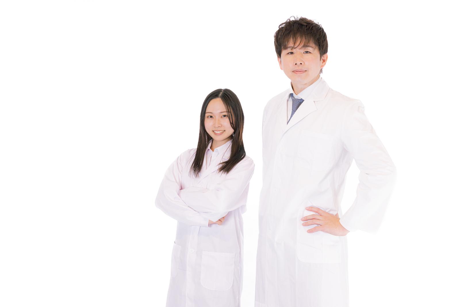 白衣姿の医師と男性M&Aアドバイザーが並んで立つポートレート写真［モデル：野崎繁裕 吉屋ゆり］