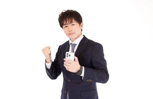 スマートフォンを持ってガッツポーズするM&Aアドバイザーの男性