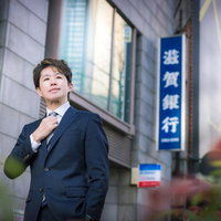 金融街のビジネス街を歩くM&Aアドバイザーの男性の写真