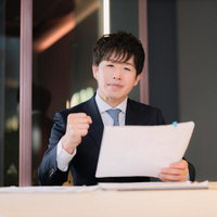 資料を持ちながらアピールするM&Aアドバイザーの写真