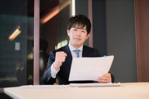 資料を持ちながらアピールするM&Aアドバイザー