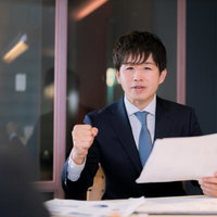 基本合意契約書の内容を詰めるM&Aアドバイザーの男性の写真