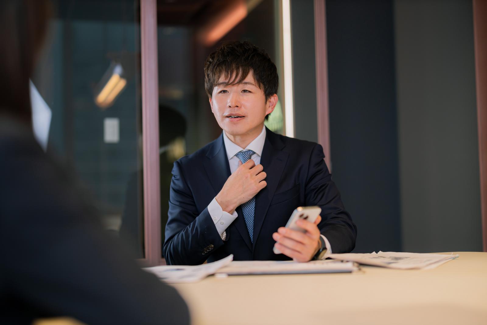 M&Aアドバイザーが商談で説明する男性［モデル：野崎繁裕］
