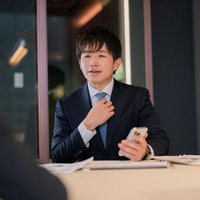 スマートフォンを片手に仕事のプレゼンを進めるM&Aアドバイザーの写真