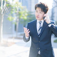 ここが変だよM&A！会社売るなら今でしょ、と電話で説明する男性会社員の写真