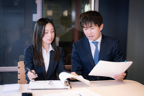 書類を見ながら打ち合わせするM&Aアドバイザーと会社員