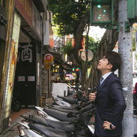 カンボジアのナイトマーケットで視察するビジネススーツの男性の写真