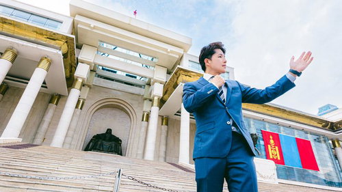 チンギスハーン広場で手を広げてプレゼンするビジネスマン