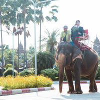 カンボジアのトゥクトゥクに乗って出張へ向かうビジネスマンの写真