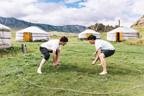 モンゴルのゲルの前で立ち合いの姿勢を取る二人の男性