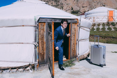 モンゴルのゲルでスーツ姿で打ち合わせするM&Aアドバイザー