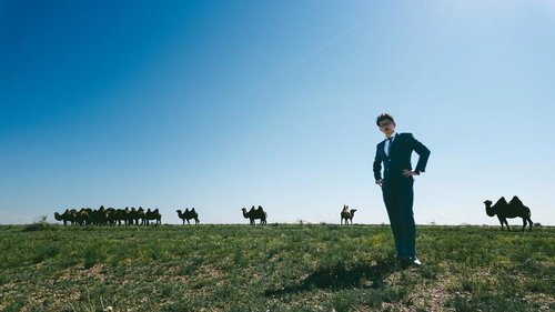 モンゴルの広大な草原にいたラクダの群れとビジネスマン