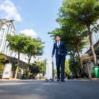 出張日和のスーツ姿の元銀行マンとキャリーケースの写真
