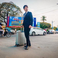 スーツ姿で異国の街路を歩くM&Aアドバイザーの写真