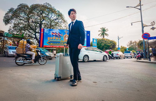 スーツ姿で異国の街路を歩くM&Aアドバイザー