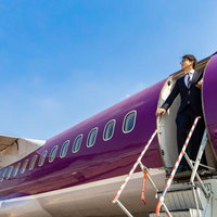 世界遺産アンコール・ワットを視察するスーツ姿の男性の写真