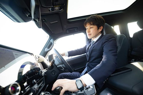 運転席でハンドルを握るスーツ姿のビジネスマン