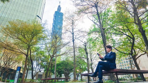 高層ビル「台北101（Taipei 101）」とくつろぐビジネスマン