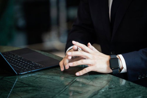 デスクで手を組み考えるビジネスマン