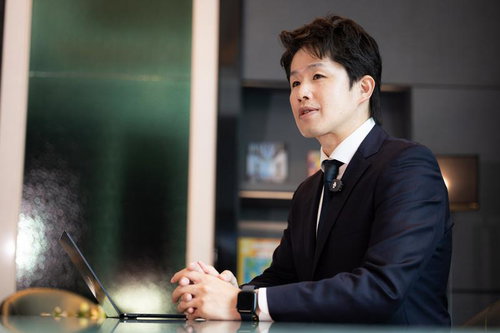 オフィスでノートパソコンを使い打ち合わせする男性