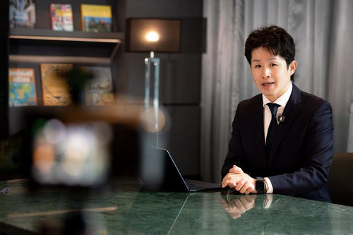 デスクに座りカメラ目線のM&Aアドバイザー