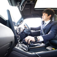 スーツ姿で車を運転するビジネスマンの写真