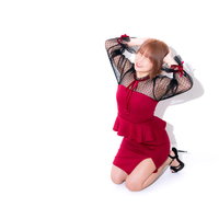 赤いパーティードレスで頭を抱えて悔しがる女性の写真