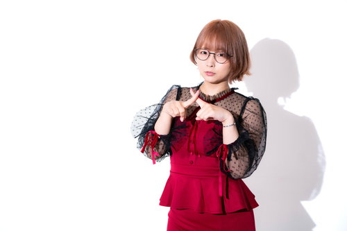 両手でバツをつくるパーティードレスのメガネ女子