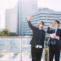 屋外で営業担当と打ち合わせを行う上司の男性の写真