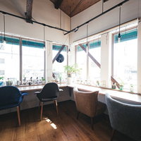 窓際に差し込む自然光が明るく照らすカフェの席の写真