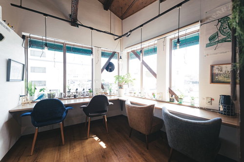 窓際に差し込む自然光が明るく照らすカフェの席