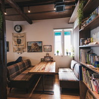 木目調テーブルとダークソファが配置されたカフェのソファー席の写真