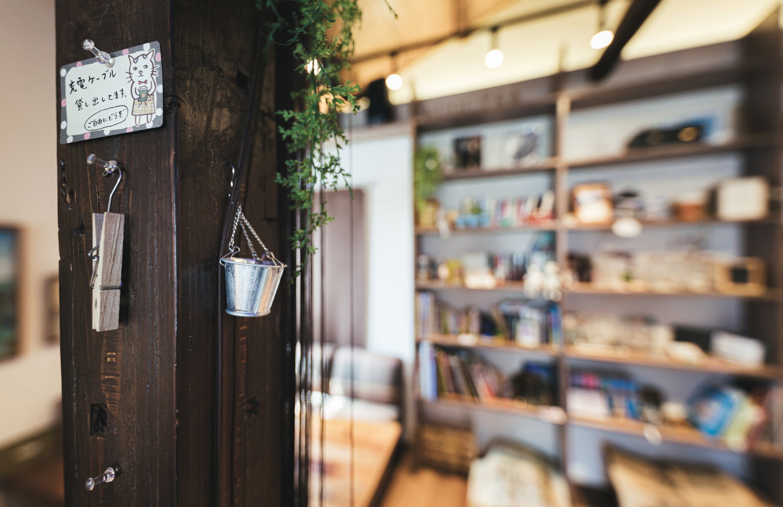 カフェの木製の柱に観葉植物が配置された店内の様子
