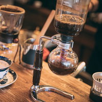 サイフォンでコーヒーを淹れる手元の抽出風景の写真