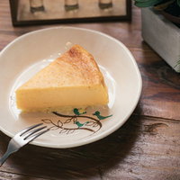 カフェの手作りチーズケーキ、白い皿に盛り付けたスライスの写真