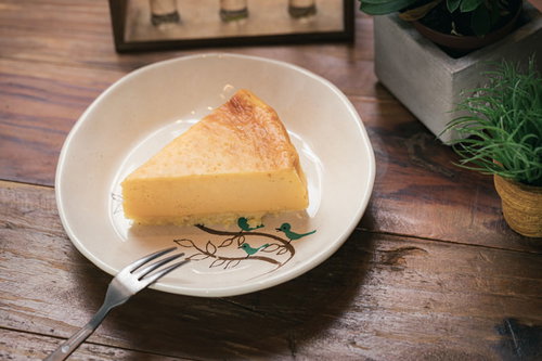 カフェの手作りチーズケーキ、白い皿に盛り付けたスライス