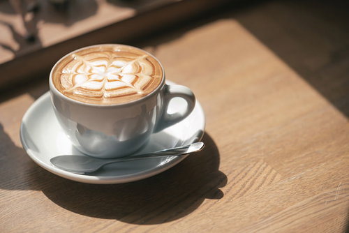 カフェの木製テーブルに置かれたラテアート