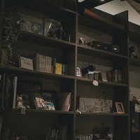 閉店時間の薄暗い本棚に並ぶ書籍の照明風景の写真