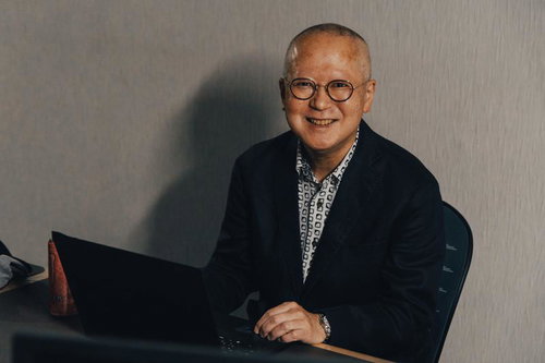 不気味な笑みを浮かべる高齢の男性従業員