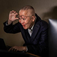 VRゴーグルを装着して時代をアピールする高齢者の男性の写真