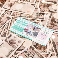年末ジャンボ宝くじで大当たり、一万円札が散らばるの写真