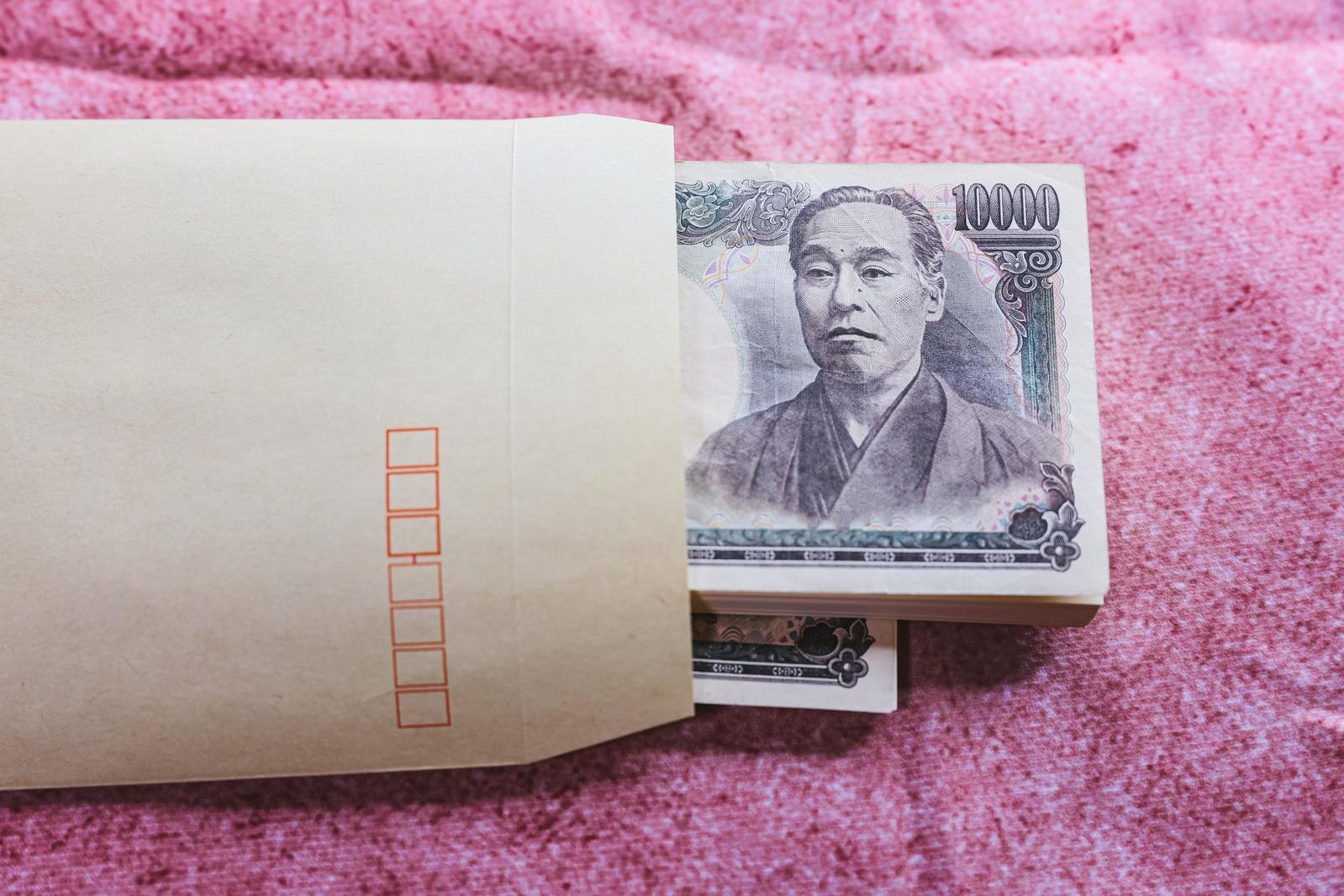 茶封筒から出ている複数の一万円札と赤い四角が描かれた白い紙