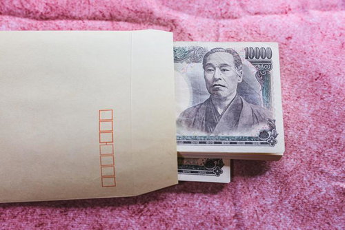 茶封筒から顔を出した一万円札の現金と賄賂