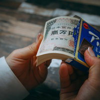 副業のバイトで稼いだ札束を数える様子の写真