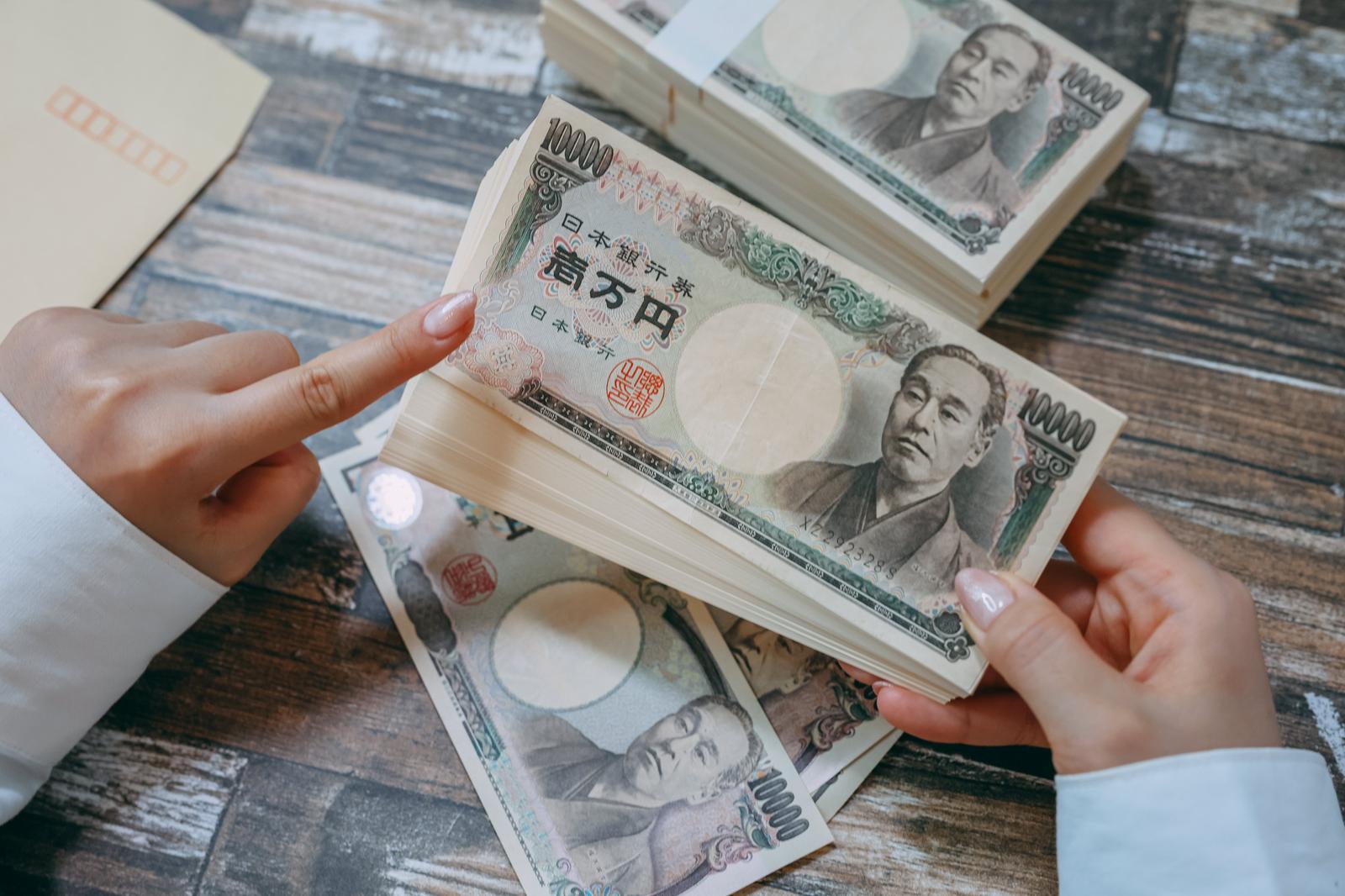 一万円札の束を両手で数える