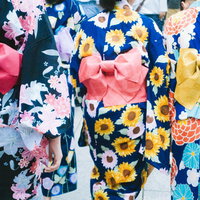 夏祭りで浴衣姿の女性たちの後ろ姿、カラフルな花柄と帯の写真