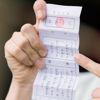 おみくじで引いた大吉を手に持つ神社参拝の運試しの瞬間の写真