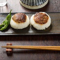 味噌が香ばしい！黒い石皿に盛り付けた焼きおにぎりの写真